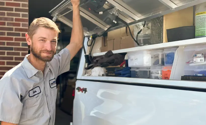 Pest control technician standing next to truck
